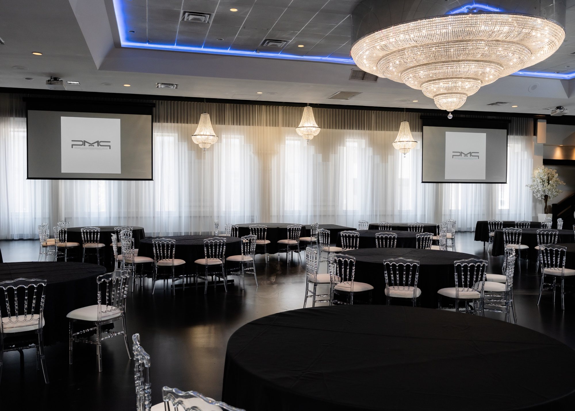 Salle aménagée avec tables pour un banquet corporatif