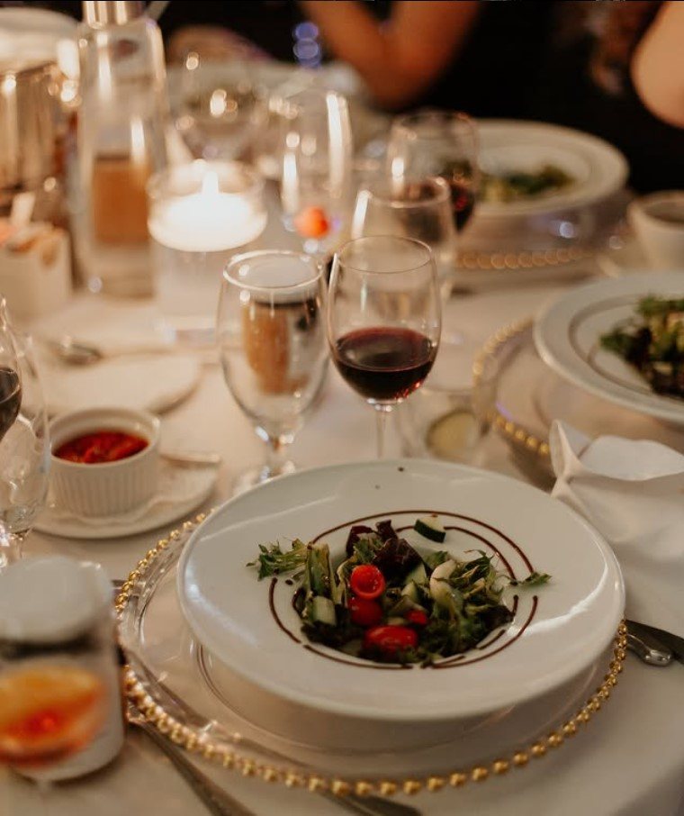 Assiette, couverts et verrerie sur une table dressée