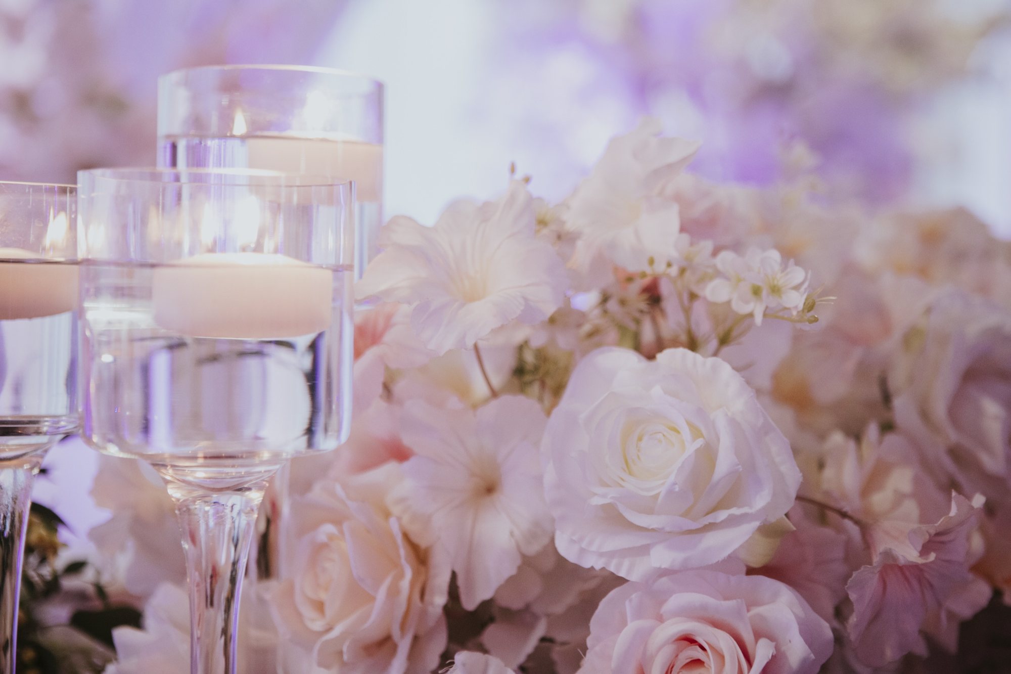 Décor de réception rose avec fleurs, tentures et bougies