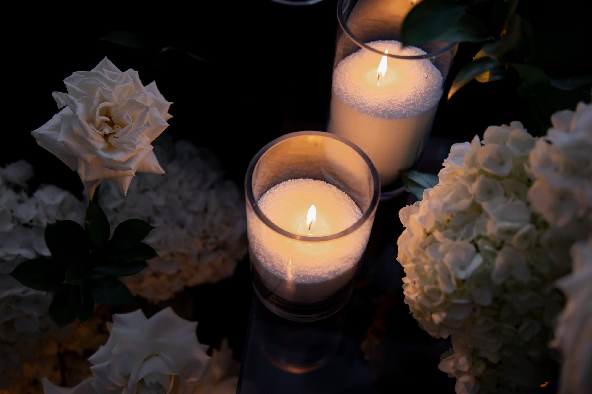 Fleurs blanches et bougies sur une table de réception