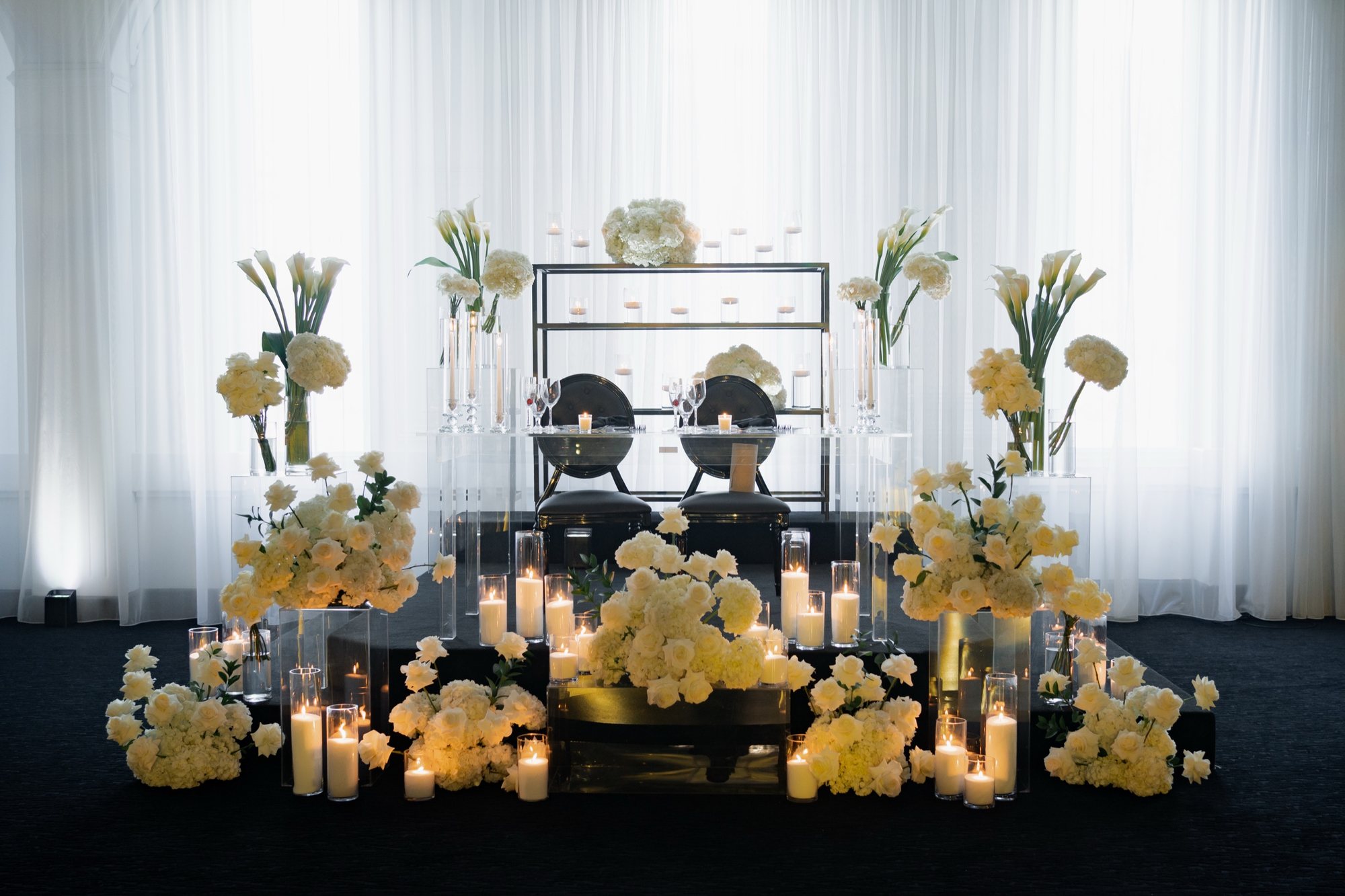 Table d’honneur entourée de fleurs blanches et de bougies