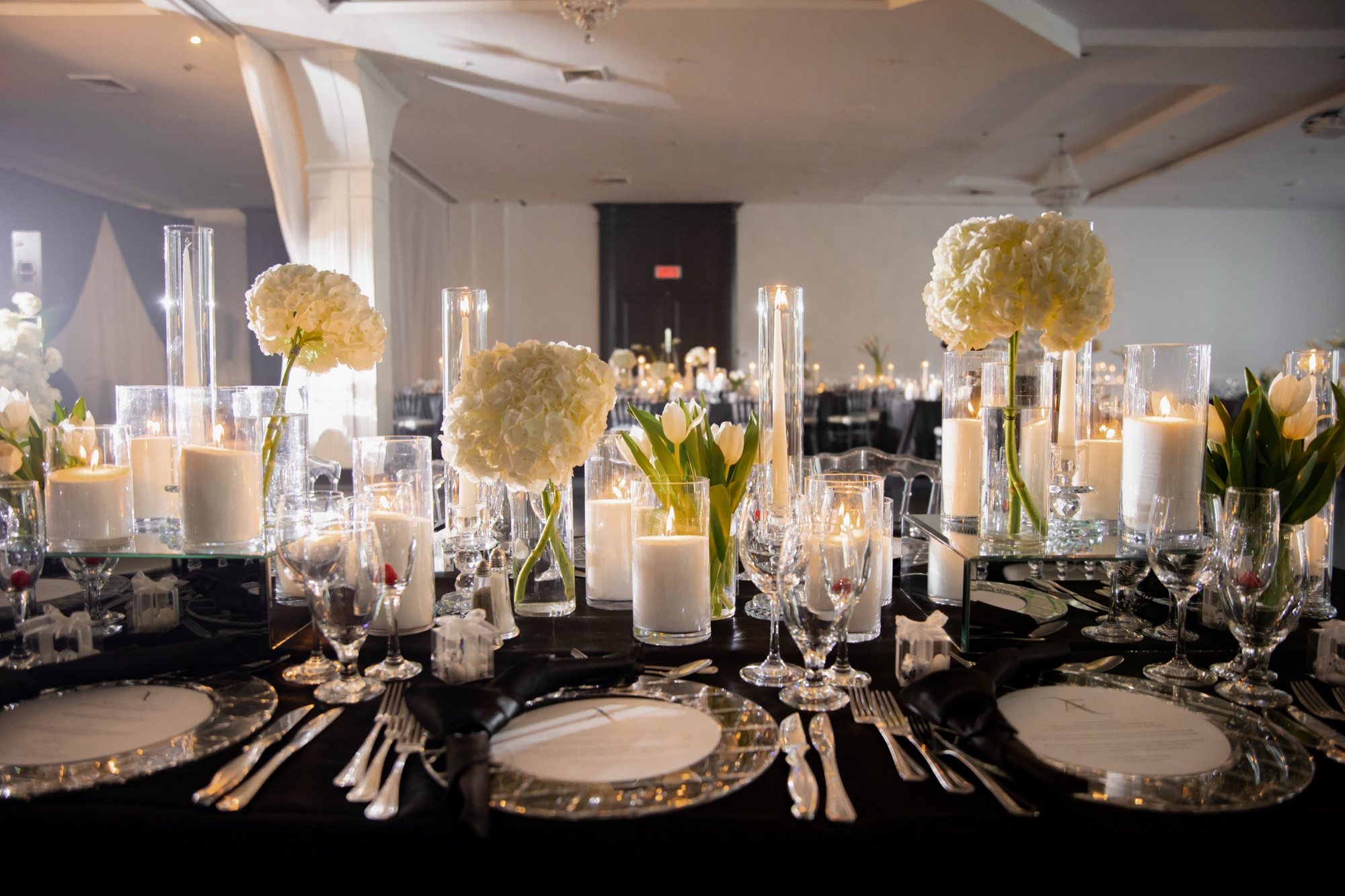 Table de réception avec fleurs blanches, verrerie et bougies