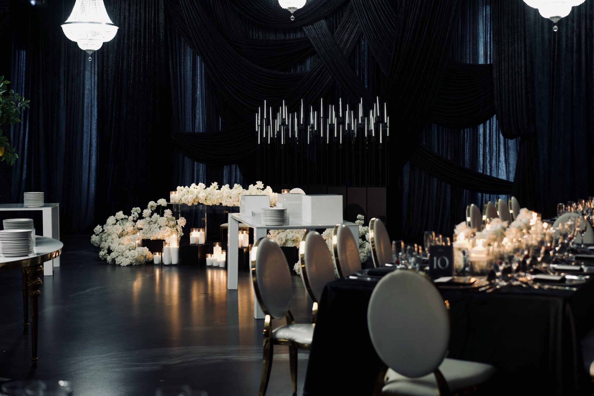 Salle de réception aux tentures noires et aux tables fleuries